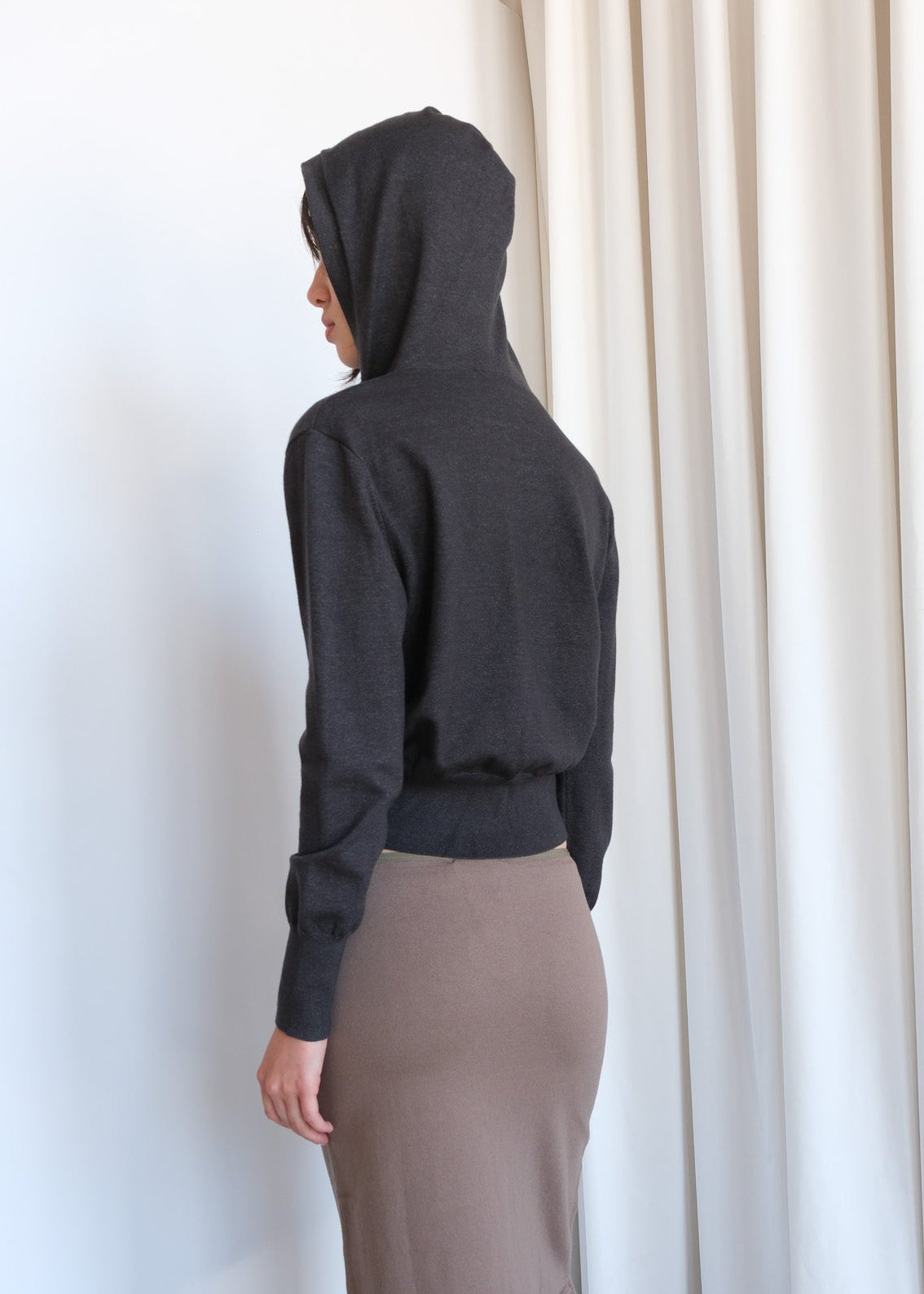 Beige Rori cardigan by geel.us with button details, shown draped on a hanger, highlighting soft knit fabric and casual style.