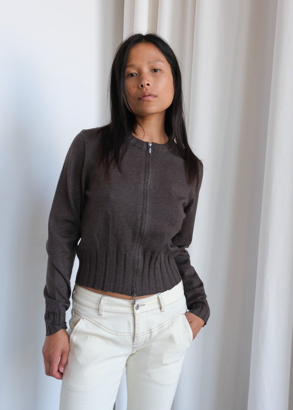 Geel Dennis Zip Cardigan, a stylish zip-up sweater in soft fabric, displayed on a hanger with a neutral background.